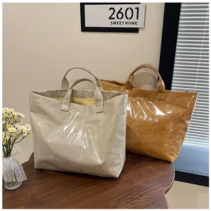 Dettaglio della borsa tote in PVC impermeabile con trama carta e chiusura magnetica