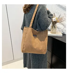 Détail de la texture velours et de l'étiquette FASHION sur ce sac cabas marron