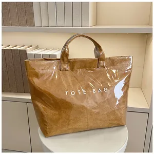 Dettaglio della borsa tote in carta marrone impermeabile con testo e rivestimento lucido