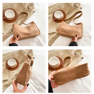 Detailweergaven van de karamelbruine corduroy baguette tas met geribbelde textuur