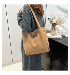 Détail d'un sac cabas en velours côtelé marron montrant l'étiquette Fashion et la texture