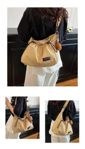 Détail du sac bandoulière en nylon kaki avec cordon de serrage et pompon pelucheux
