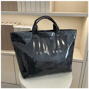Borsa tote nera lucida in PVC con scritta bianca TOTE BAG su piedistallo bianco pulito