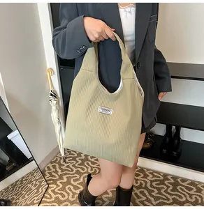 Detail of light green corduroy tote bag showing soft texture and Fashion Instinct label
