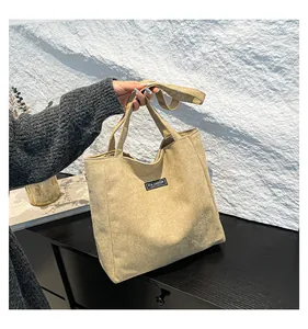Détail du sac cabas en daim kaki avec étiquette Fashion Instinct et bandoulière