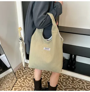 Detailed view of olive corduroy tote bag with Fashion Instinct woven label and texture