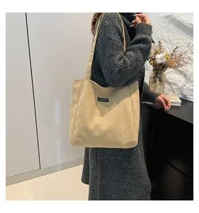 Détail du sac cabas en velours côtelé beige avec étiquette fashion et texture de bandoulière