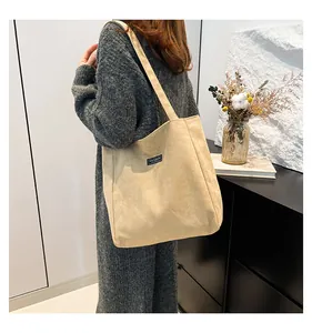 Détail du sac cabas en velours côtelé beige avec étiquette Fashion et tissu texturé