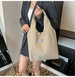 Detail of khaki pleated corduroy tote bag featuring a white Fashion Instinct label