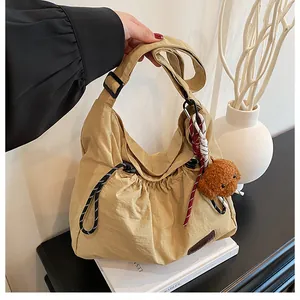 Détail du sac à cordon en nylon kaki avec ours en peluche et bandoulière réglable