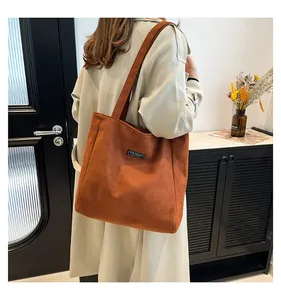 Détail du sac fourre-tout en velours côtelé marron avec étiquette mode sur mannequin
