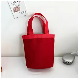 Detail der roten Canvas-Beuteltasche mit strukturierten Griffen und schlichten Nähten