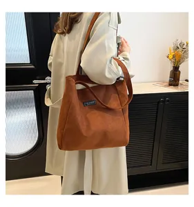 Détail du sac cabas en velours côtelé caramel avec étiquette fashion sur tenue chic
