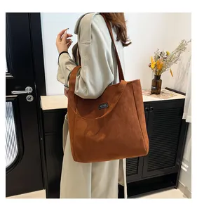 Sac fourre-tout en daim marron caramel avec étiquette tendance et bandoulière longue