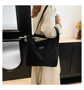 Détail du sac cabas en daim noir avec étiquette FASHION montrant sa grande capacité