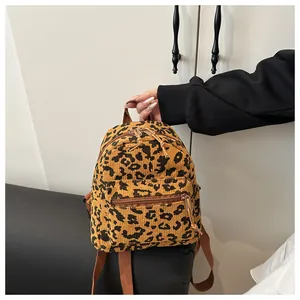 Detail der Textur des Cord-Rucksacks mit Leopardenmuster, stabilen Reißverschlüssen und Trägern
