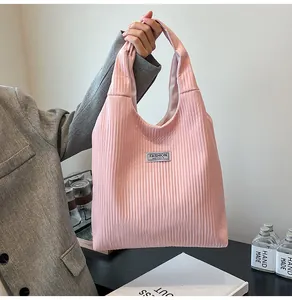 Detail of pink pleated corduroy tote bag featuring a Fashion Instinct woven label