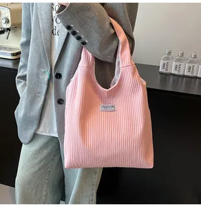 Close-up of pink corduroy tote bag featuring pleated texture and FASHION INSTINCT label