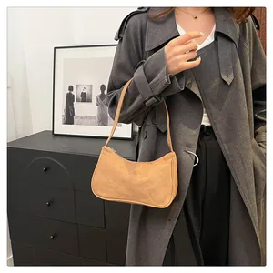 Detail van de camel suède baguette tas met matte textuur en soepele ritssluiting