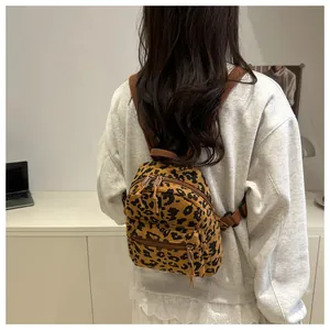Detailansicht eines Cord-Rucksacks mit Leopardenmuster, zeigt Größe und Textur am Modell