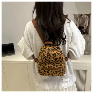 Detail eines Mini-Cord-Rucksacks mit Leopardenmuster und Doppelreißverschluss am Model
