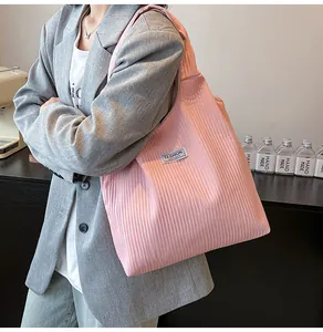 Detail of pink pleated corduroy tote bag featuring white Fashion Instinct label and soft texture