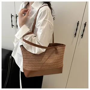 Close-up of woven straw texture and premium brown leather straps on a tote bag