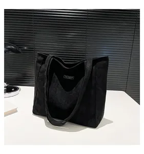 Détail du grand sac cabas noir en daim montrant l'étiquette intérieure et la texture