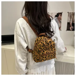 Detail eines Cord-Minirucksacks mit Leopardenmuster, getragen in modernem Raum