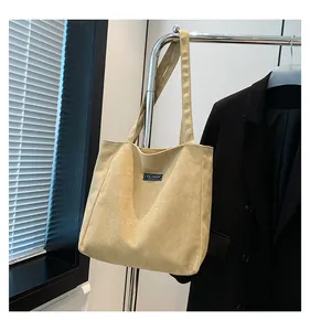 Détail du sac cabas en velours côtelé beige avec étiquette Fashion et texture douce