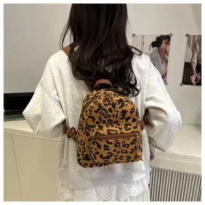 Detail eines Mini-Rucksacks mit Leopardenmuster und verstellbaren Trägern auf dem Modell