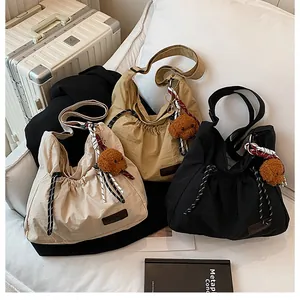 Sacs bandoulière en nylon beige, kaki et noir avec pendentif ours et détails de cordon