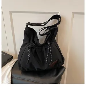 Détail du sac en nylon noir avec cordon de serrage et étiquette en cuir à la mode