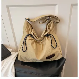 Détail du sac bandoulière en nylon kaki avec cordon de serrage et écusson en cuir FASHION