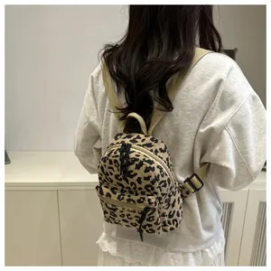 Detailansicht des Cord-Rucksacks mit Leopardenmuster am Modell in Innenräumen
