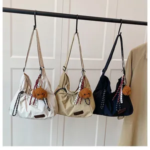 Détail de sacs à bandoulière en nylon avec cordon de serrage et pendentifs chien