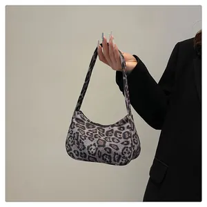 Detailopname van de baguette-tas met luipaardprint en de metalen ritssluiting