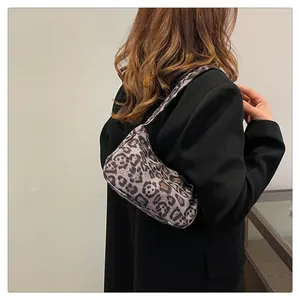 Detail van de dames hobo tas met luipaardprint gedragen met een trendy zwarte blazer