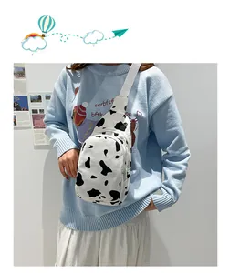 Detail of cow print canvas chest bag with double zippers and adjustable white strap