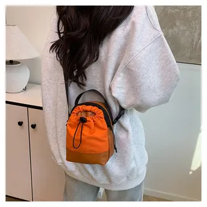 On-body shot of a mini orange drawstring crossbody bag for phone and essentials