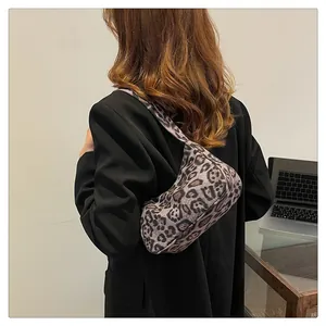 Achteraanzicht van een model met de luipaardprint suède okseltas voor maat en stijl