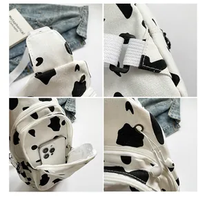 Detailed stitching and inner compartment of cow print canvas chest bag with adjustable strap
