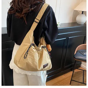 Détail du sac besace demi-lune en nylon kaki avec cordon de serrage et pendentif peluche