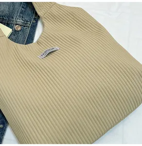 Detail of beige corduroy tote bag with Fashion Instinct label and pleated texture
