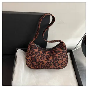 Detailopname van hobo-tas met luipaardprint en ritssluiting in luxe geschenkdoos