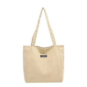 Sac fourre-tout minimaliste en velours côtelé beige avec écusson et longues bandoulières