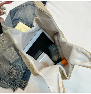 Detailed interior of a beige corduroy tote showing spacious storage for tablet and makeup