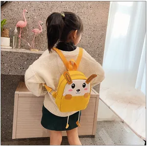 Vue détaillée d'un sac à dos lapin jaune pour enfants porté par une petite fille