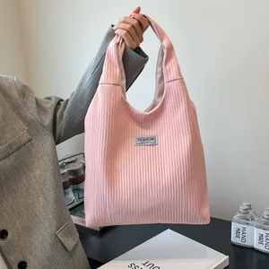 Pink corduroy tote bag with Fashion Instinct label shown in a minimalist urban style