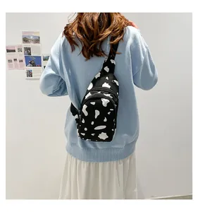 Detailed back view of a canvas cow print chest bag with black nylon straps and zippers
